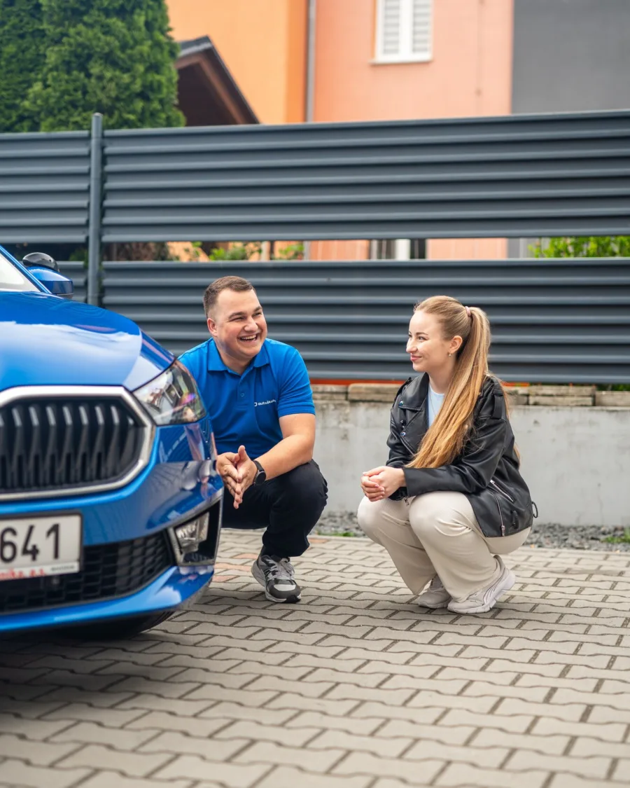 Lektor vysvětluje žačce kontrolu auta před jízdou